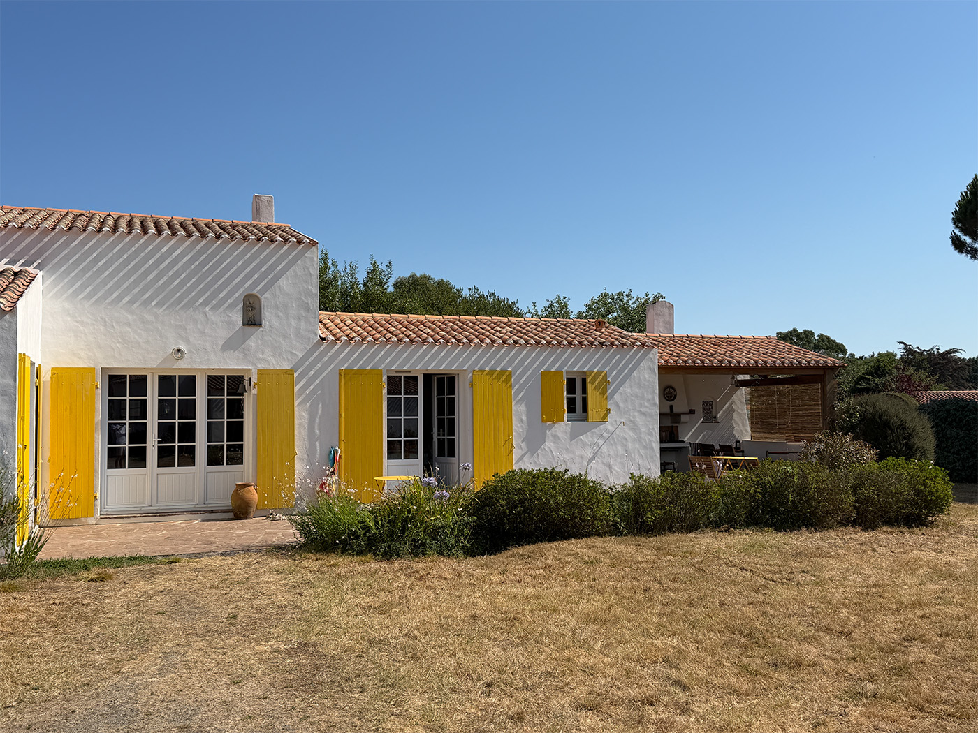 La Maison Jaune bei Tag, Terrasse und überdachter Essbereich